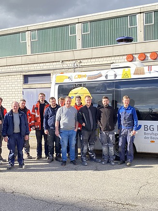 Foto von gewerblichen ZÜBLIN Timber Kollegen, die vor dem BG BAU-Bus stehen.