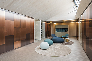 Foto der Anwaltskanzlei FGS Augsburg. Moderner Innenraum mit vielen Holzoberflächen und Sitzsäcken.