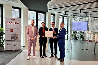 Aktuelles ZÜBLIN Timber. v.l.n.r.: Dr. Marco Xaver Bornschlegl, Zentralbereichsleiter STRABAG Innovation & Digitalisation; Prof. Dr. Katja Rade, Rektorin der Technischen Hochschule Stuttgart; Cem Özdemir, Bundesminister für Ernährung und Landwirtschaft; Markus Landgraf, ZÜBLIN Vorstandsmitglied Foto von vier Personen im ZÜBLIN-Innovation-Center, die ein kleines Schild halten.