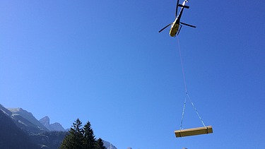 Photo of the timber construction assembly of the Waltenberger Haus in Oberstdorf. Helicopter assembly of the LENO CLT elements.