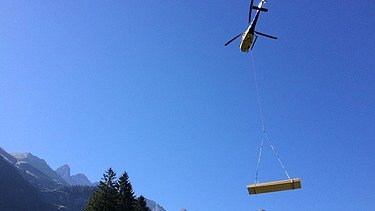 Photo of the timber construction assembly of the Waltenberger Haus in Oberstdorf. Helicopter assembly of the LENO CLT elements.