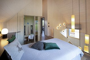 Photo of the furnished living room of the Chalet Engel in Baiersbronn. Many wooden surfaces can be seen.