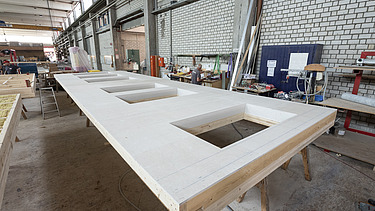 Photo of a horizontal LENO ADD element in the ZÜBLIN Timber production hall. 