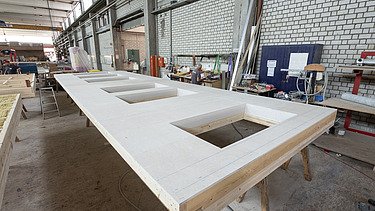 Photo of a horizontal LENO ADD element in the ZÜBLIN Timber production hall. 
