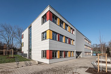 Schule, Erfurt Außenaufnahme der Schule in Erfurt. Man sieht ein großes, weißes Gebäude mit bunten Farbelementen bei den Fenstern.