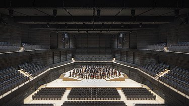Photo of the interim venue Gasteig in Munich. You can see the seated stage area with orchestra.