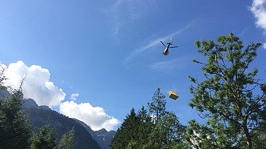 Foto der Holzbaumontage des Waltenberger Haus in Oberstdorf. Helikopter-Montage der LENO-BSP-Elemente.