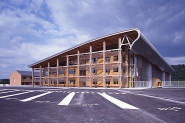 Photo of the Mirecourt school in France. You can see a large wooden building.