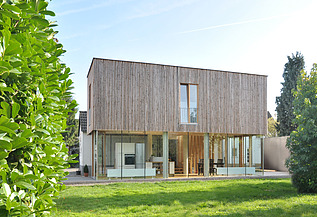 Foto eines Holzhauses mit Flachdach. LENO-BSP.