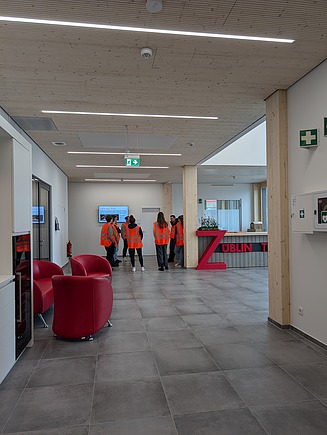 Foto des Empfangsbereiches des Bürogebäudes T3 von ZÜBLIN Timber mit Personen