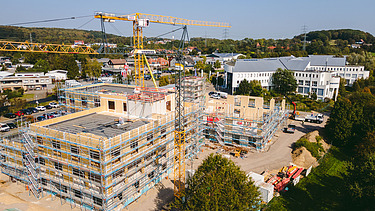 Photo of Witten University from the outside. You can see the assembly of large wooden elements from a bird's eye view