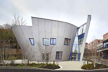 Foto eines Gebäudes mit Holzfassade und schrägen Wänden