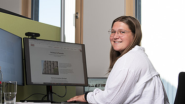 Foto einer jungen Frau am PC-Arbeitsplatz. Ausbildung Industriekauffrau:man.