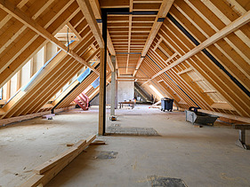 Photo of the VINZENT building shell in Munich. You can see the wooden roof truss.