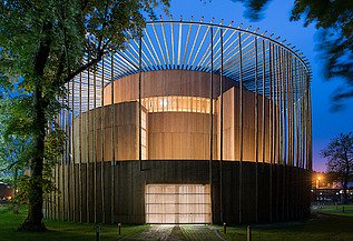 Elizabethan Theatre Condette Photo of the Elizabethan Theater in Condette France. You can see a round wooden building at night.