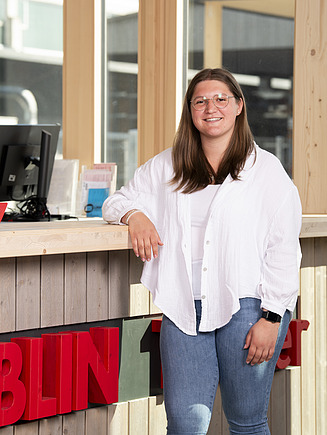 Photo of a young woman smiling at the camera. Training at ZÜBLIN Timber.