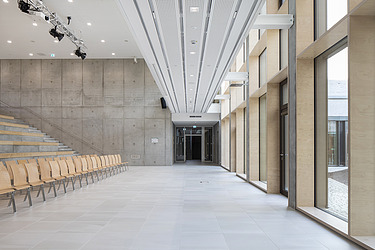 Foto des Innenraums der Vinzenz-Pallotti-Schule in Friedberg. Der Fokus liegt auf der Pfosten-Riegel-Fassade aus Holz.