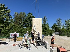 Construction site photo showing the assembly of the first cross-laminated timber elements.