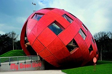 Regierungspavillion Floriade NL-VENLO Foto eines rießigen, schrägliegenden Holzeis mit orangefarbiger Holzfassade und Fenstern.
