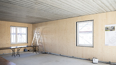 Photo of a building shell. You can see the wooden walls. 