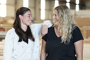 Photo of two ZÜBLIN Timber employees smiling at each other.