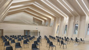 Photo of a seated hall with a large visible ribbed wooden construction.