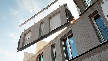 Foto der Montage von LENO-ADD-Holzbauelementen, auf der Baustelle Quartier Hangweide in Kernen