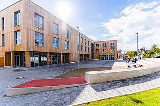 Photo of Witten University from the outside. You can see a large wooden building.