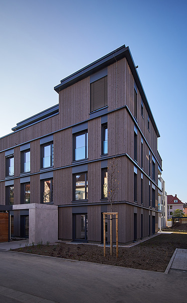 Photo of a multi-storey residential building with a wooden façade.