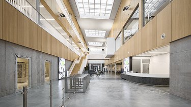 Photo of a large interior with many concrete and wooden surfaces.