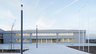 Foto der Sporthalle des Gymnasiums in Diedorf. Holzbau von außen.