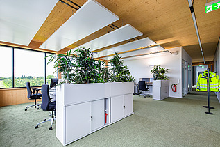 Foto eines modernen, möblierten Büroinnenraumes mit Holzdecke.