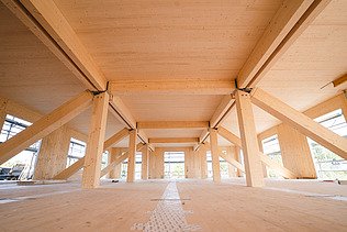 Photo of Witten University from the inside. You can see glulam beams and a large LENO wooden ceiling.