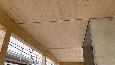 Foto eines Rohbaus aus Holz. Man sieht einen Innenraum mit Holzdecke.