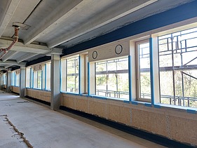 Photo of an interior on the building site. You can see an installed timber frame wall.