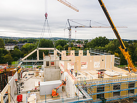 Photo of Witten University from the outside. You can see the assembly of large wooden elements.