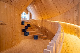 Photo of the NEXT500 pavilion on Augsburg's market square. You can see a modern interior made of wood.