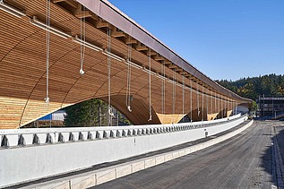 Foto einer Rodelbahn. Man sieht eine Holzüberdachung und nur einen Ausschnitt davon