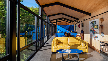 Foto eines Wohnhauses aus Holz auf Stahlpfählen, inmitten des Waldes.