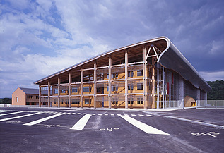Foto der Schule Mirecourt in Frankreich. Man sieht ein großes Holzgebäude.