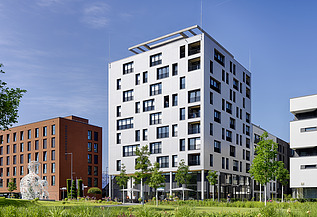 SKAIO Stadtsiedlung Heilbronn Foto des Gebäudes SKAIO Stadtsiedlung in Heilbronn. Man sieht ein mehrgeschossiges, weißes Gebäude.