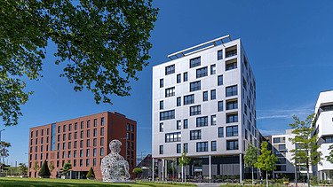 Foto eines mehrgeschossigen Gebäudes mit weißer Fassade.