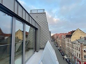 Photo of a wooden extension. You can see a window detail high up.