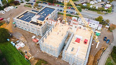 Photo of Witten University from the outside. You can see the assembly of large wooden elements from a bird's eye view