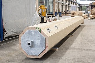 LENO-KIT from ZÜBLIN Timber. Glulam beams Photo of a long, octagonal, thick glulam beam in the ZÜBLIN Timber factory hall.