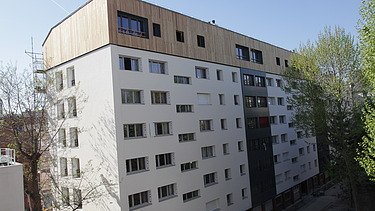 Photo of a multi-storey building with a timber extension.