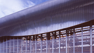 Photo of the Mirecourt school in France. You can see a section of the wooden building.