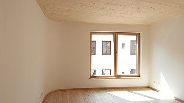 Photo of a wooden house. Detailed picture of unfurnished living room with visible LENO wooden ceiling.