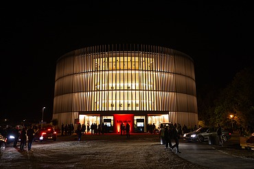 Nachtaufnahme des Globe Theaters in Coburg. Zu sehen ist ein rundes Gebäude aus Holz.