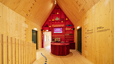 Photo of the NEXT500 pavilion on Augsburg's market square. You can see a modern interior made of wood.